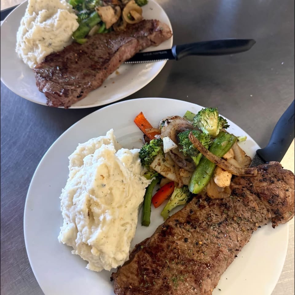 Steak dinners with mashed potatoes and vegetables